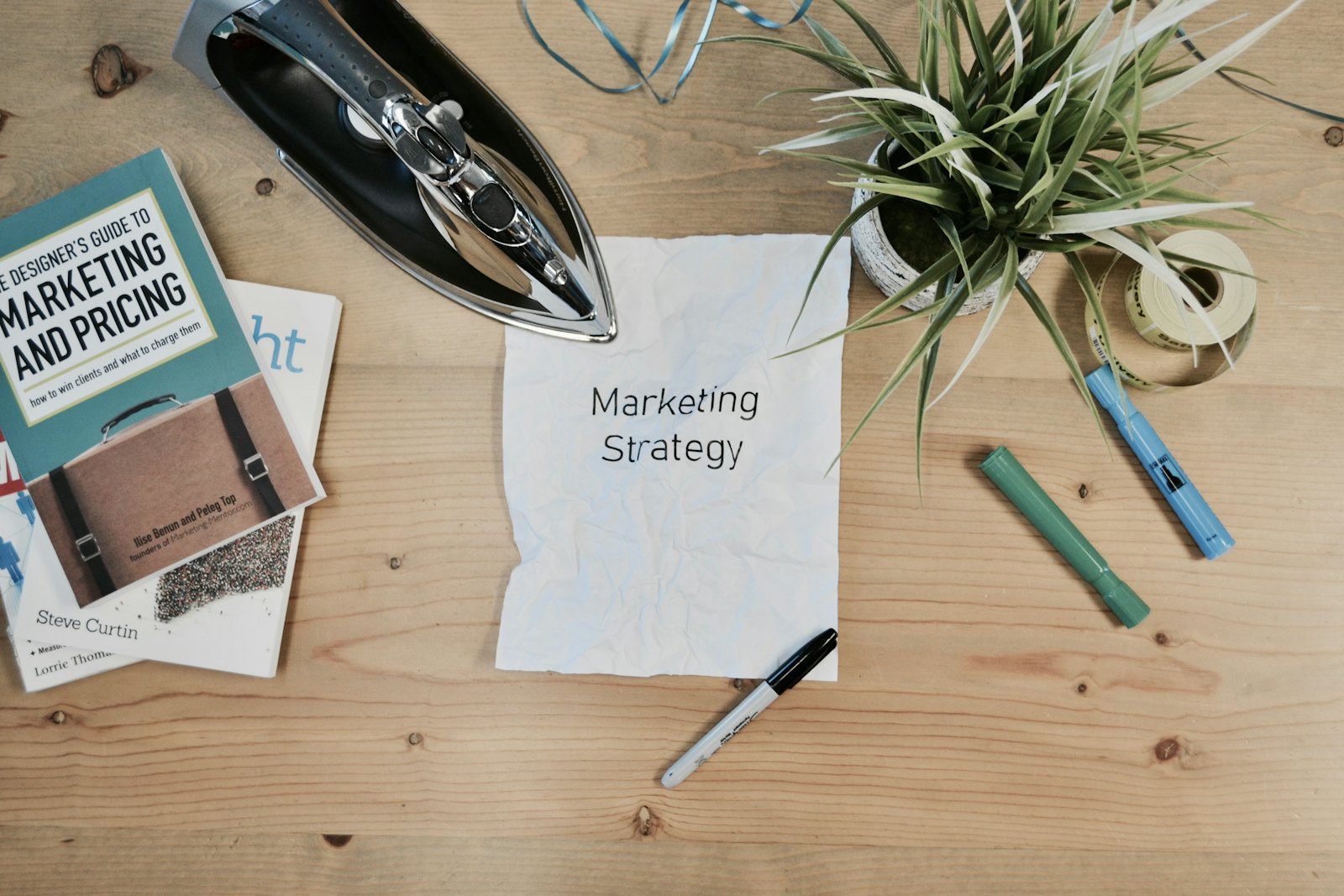 Tờ giấy ghi Marketing Strategy cùng sách về marketing trên bàn